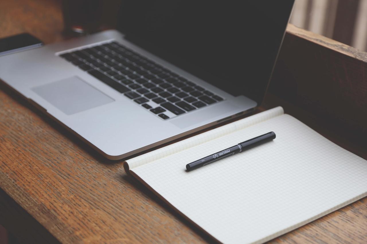 Writing a dissertation chapter on a computer and using a pen to take notes